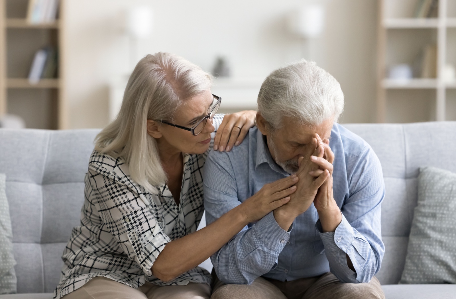 A loving, empathetic senior consoles their confused husband, who is experiencing memory loss, giving comfort and support.