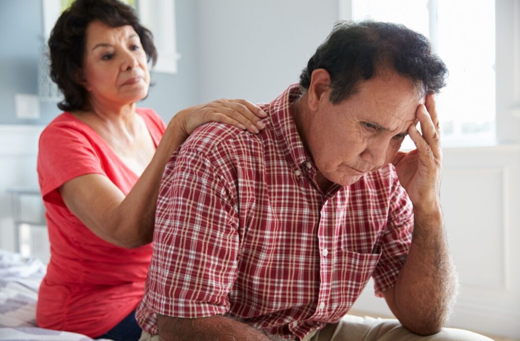 A senior comforts their senior husband, who is experiencing dementia.